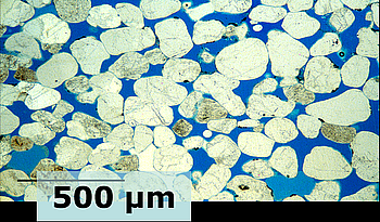 Dünnschliffaufnahme eines Sandsteins (Bildbreite ca. 2 mm). Bei der geologischen Speicherung wird der Porenraum des Speichergesteins (hier in blau) weitgehend mit CO2 gefüllt